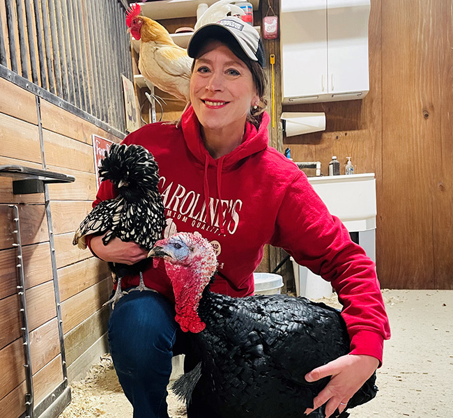 woman embraces a turkey and a chicken while a rooster perches on her shoulder she realizes there are many things which must be learned to make keeping chickens and other fowl a success for you and the birds