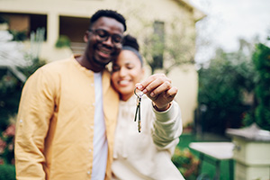 young couple hold the keys to the home they just bought after learn more about down payment